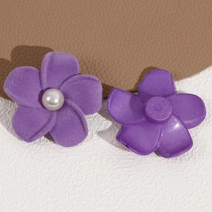 Macro shot of purple flocked flower charm showing front pearl detail and back mount base