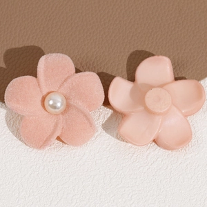 Detail of pink flocked flower charms with center faux pearl and smooth resin base