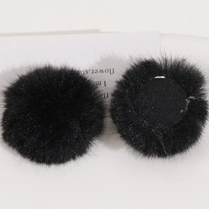 Detailed close-up of 50mm black faux rabbit fur pom poms with flat base for DIY crafts