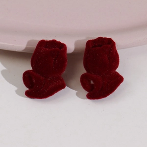 Detalle de los pendientes de tulipán granate con textura de terciopelo flocado