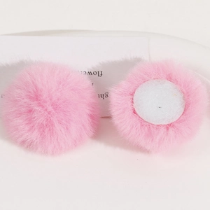 Detail view of 50mm soft pink faux rabbit fur pom poms with round bases for DIY hair clips