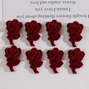 Detailed view of eight dark red flocked rose charms with velvet texture for DIY jewelry