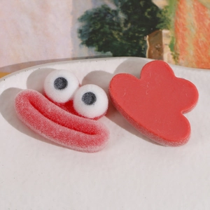 Détail d'accessoires en résine rouge floquée avec yeux de dessin animé et forme de cœur