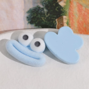 Détail d'un personnage de dessin animé bleu et d'un accessoire en résine sur un plateau blanc