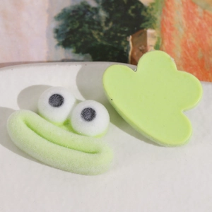 Détail de breloques grenouilles floquées vertes et accessoires de pinces à cheveux
