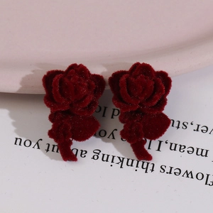 Elegant flocked burgundy rose earrings with stem detail on a white display card