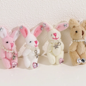 Détail de porte-clés lapin en peluche avec colliers de perles et breloques en étoile