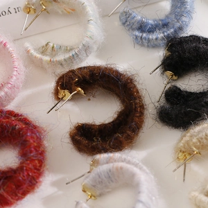 Macro shot of assorted colorful yarn-wrapped C-shape earrings for autumn and winter