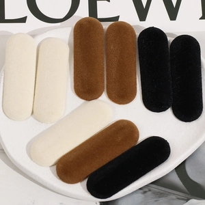 Gros plan de barrettes ovales floquées en velours beige marron et noir
