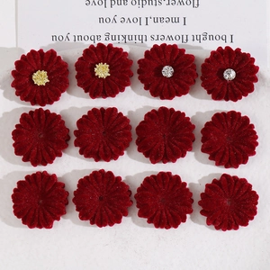 Macro shot of twelve velvet daisy flower charms in burgundy red for DIY jewelry and hair crafts