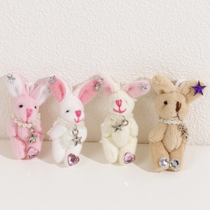 Détail de quatre porte-clés lapins en peluche avec colliers de perles et paillettes