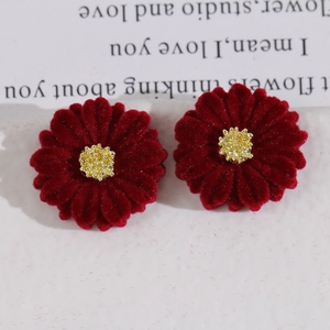 Detailed macro view of burgundy velvet flower charms with golden beaded stamens