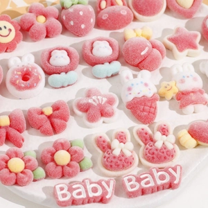 Macro view of assorted pink DIY resin charms including strawberry and bunny shapes