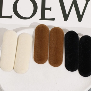 Lot de six barrettes ovales floquées en beige, marron et noir sur une assiette blanche