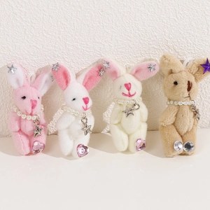 Gros plan de porte-clés lapin en peluche en quatre couleurs avec perles et étoiles