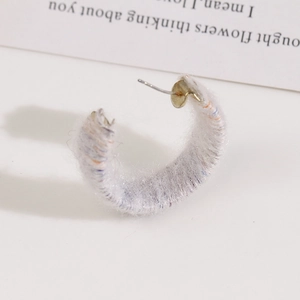 Detail of C-shaped earring wrapped in light grey plush mixed yarn with metal stud