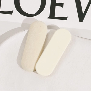 Détail de deux barrettes ovales en résine floquée beige clair sur une assiette blanche