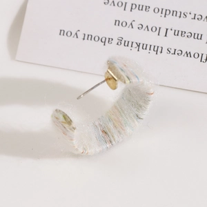 Detailed macro shot of multi-colored plush yarn wrapped around a C-shape metal earring