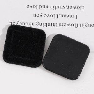 Macro shot of square black flocked resin patches with soft velvet texture for DIY crafts