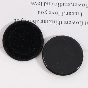 Close-up of black flocked and smooth resin circular DIY jewelry accessory parts