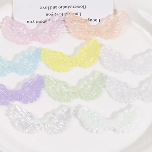 Macro detail of gradient glitter angel wing resin patches for DIY craft and accessories