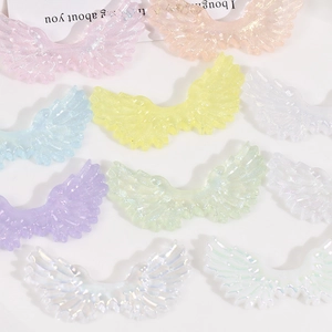 Close-up of colorful glitter acrylic angel wings with iridescent starry gradient finish