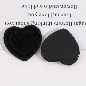 Detail showing matte black flocked heart-shaped resin patch with smooth adhesive back surface