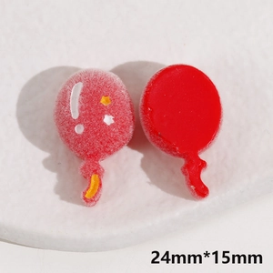 Macro shot of 24x15mm red balloon charms for DIY jewelry with velvet and resin texture