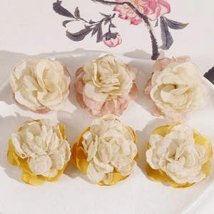 Detail of multi-layered fabric mesh rose flowers in soft pink and yellow for DIY hair clips