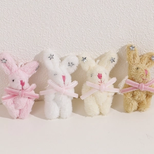 Détail de quatre pendentifs lapins en peluche avec nœuds velours et étoiles