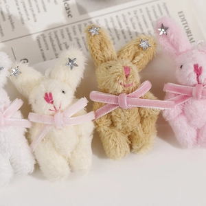Détail de breloques lapins en peluche avec nœuds en velours et sequins étoiles argentés