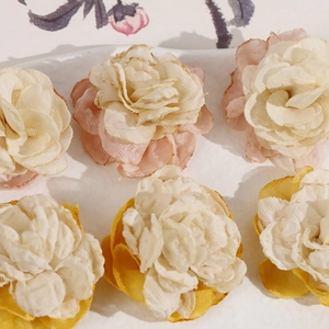 Detail showing multi-layer mesh rose fabric flowers in pink and yellow color gradients
