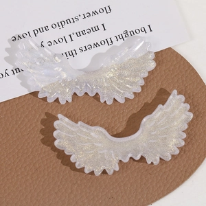 Close-up of glittery acrylic angel wings with golden sequins for DIY jewelry making