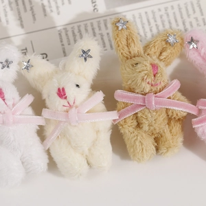 Gros plan de breloques lapins en peluche avec nœuds en velours et étoiles sur fond vintage