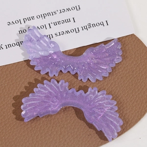 Macro detail of purple glittery angel wing acrylic charms for DIY jewelry making accessories