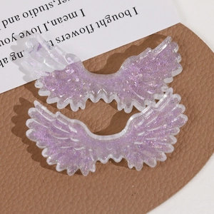 Macro shot of purple glitter angel wings resin charms for DIY jewelry and hair accessories