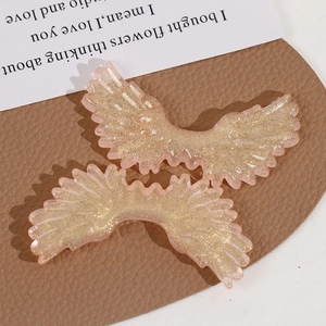 Macro detail of gradient pink glitter angel wings acrylic DIY jewelry accessories