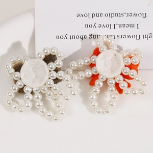 Handmade pearl flower craft accessory with velvet center in brown and orange colors