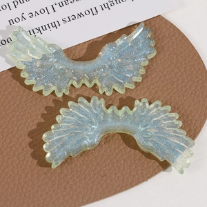 Macro shot of glittery cyan angel wings made of resin with starry blue sparkling powder