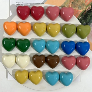Detailed view of colorful glossy resin heart charms arranged in a white circular tray