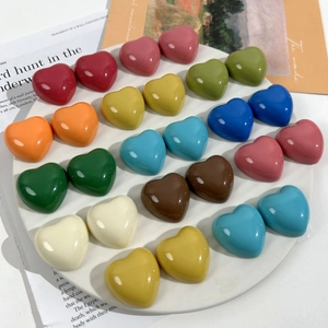 Glossy colorful resin heart charms for DIY crafts and jewelry making on white tray