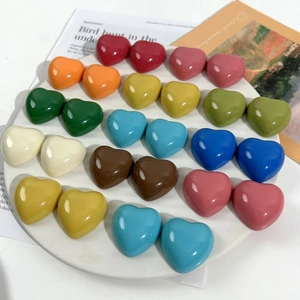 Close-up of colorful glossy resin heart charms for DIY crafts in various vibrant colors