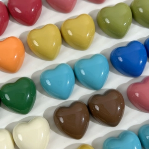 Close-up of colorful glossy resin heart charms for DIY crafts and hair accessories