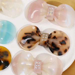 Detailed macro of acetate bow hair clips with rhinestones in various pearl colors