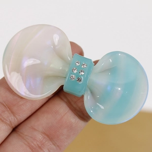 Close-up of pearlized acetate bow with blue gradient and sparkling rhinestones