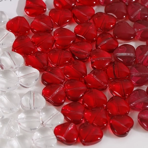 Dettaglio di perline di vetro traslucido a forma di cuore rosse e trasparenti per fai da te