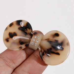 Close-up of a tortoiseshell acetate bow hair clip with sparkling inlaid rhinestones