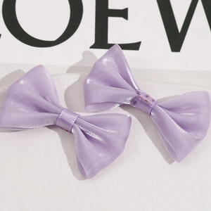Detalle de dos pinzas para el pelo con lazos de malla suave de color púrpura claro