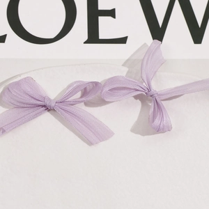 Detail of light purple mesh bow accessories displayed on a white ceramic plate
