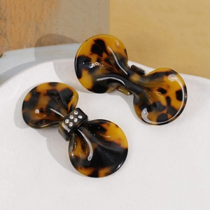 Detail of tortoise shell acetate bow hair clips with embedded white rhinestones